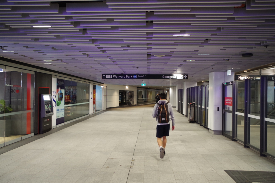 image of a person walking away through a transport centre passage