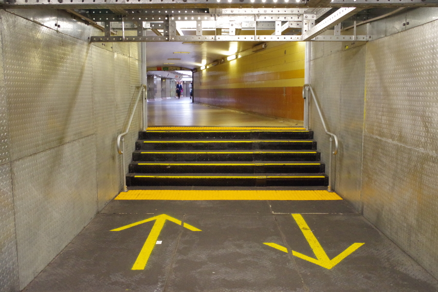 image of a basement passageway with arrows on the ground showing to keep left